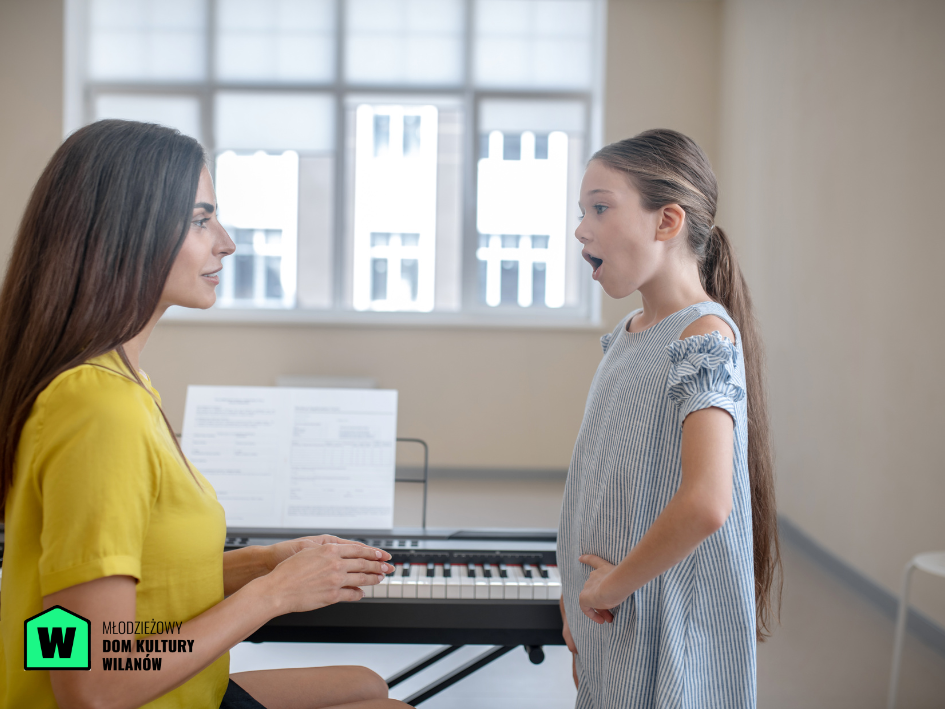 Instruktorka ucząca śpiewać dziewczynkę, lekcja muzyki