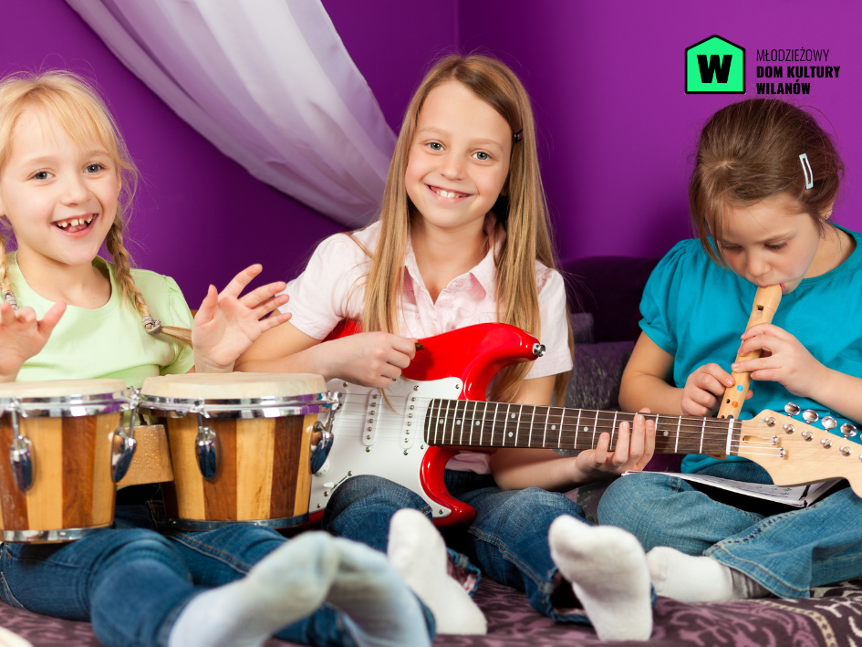 Trzy uśmiechnięte dziewczynki. Jedna gra na bębenkach, druga na gitarze, trzecia na flecie.