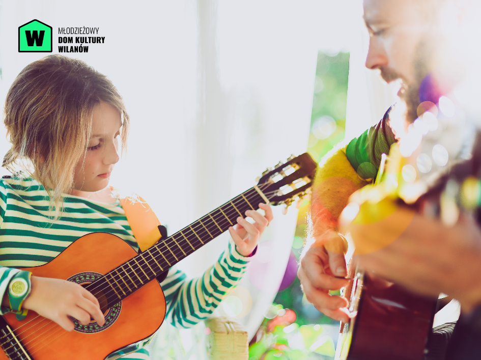 Instruktor i dziewczynka, trzymający w rękach gitary, uczący się na nich grać.